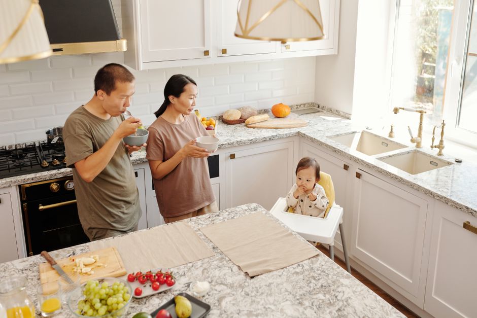 A family sitting together at a table in a bright home kitchen.